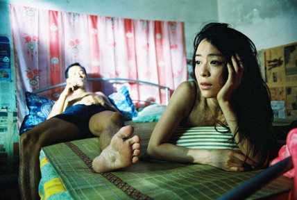 Wong Xiaoling sitting on the bed in the family flat